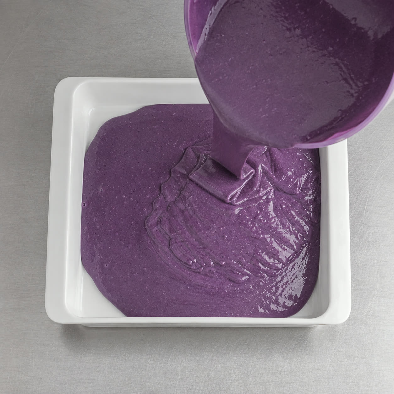 Pâte à gâteau à l'ube violette versée dans le moule, prête à enfourner | Ube Nolia