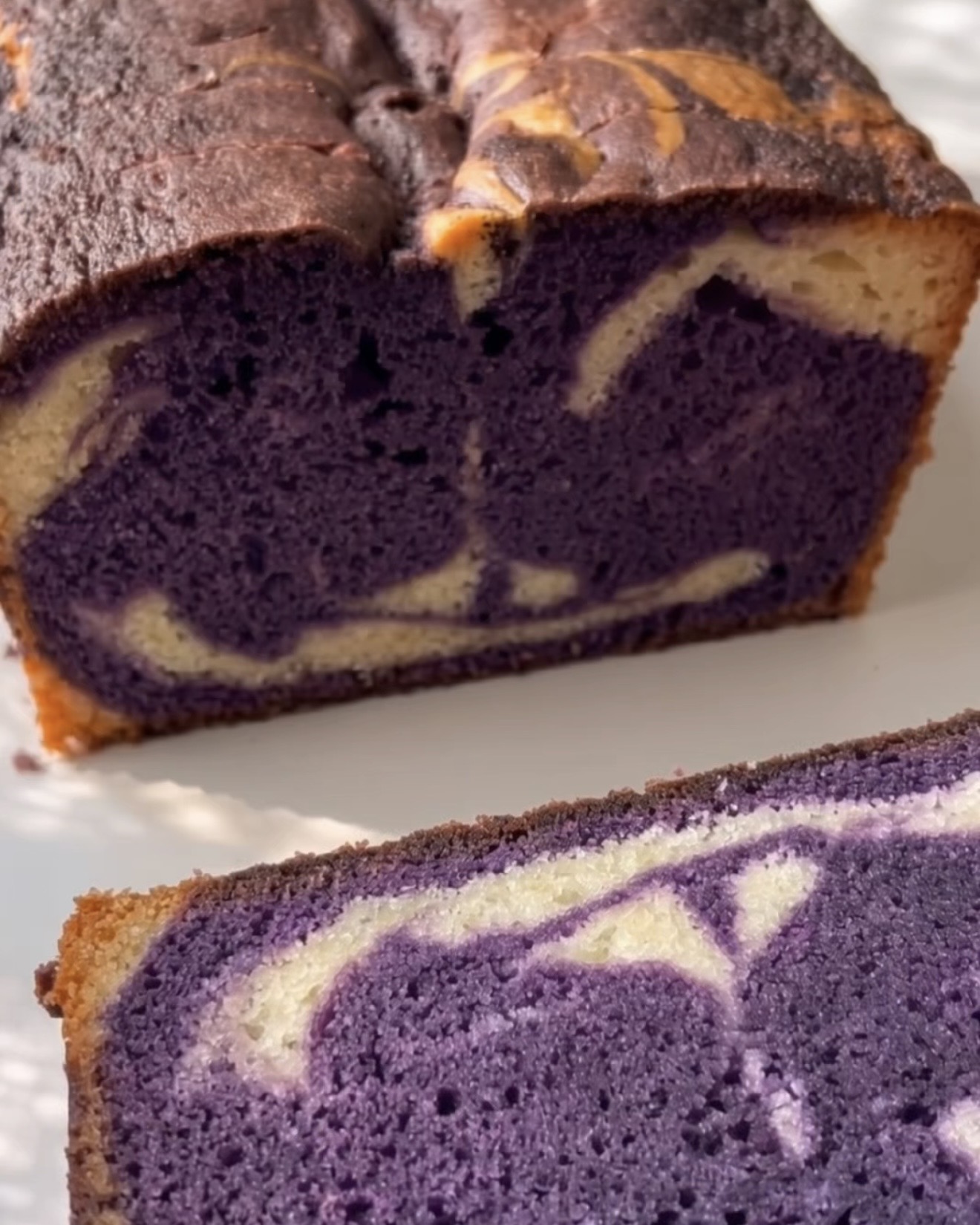 Cake marbré ube cuit, coupé pour montrer le tourbillon violet et vanille, fait avec de la poudre d'ube Ube Nolia