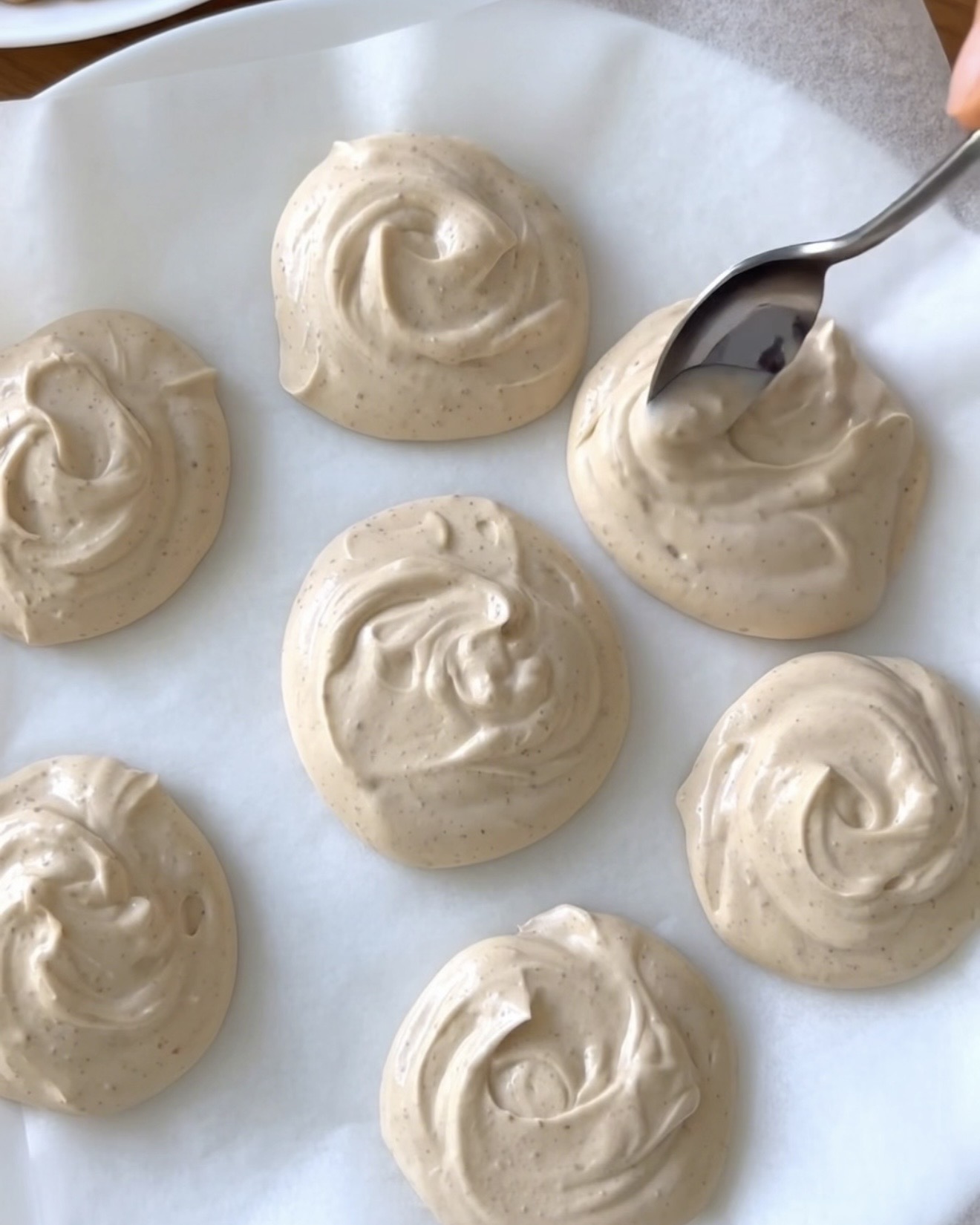 Petites portions crémeuses de yogourt grec au beurre d'arachide sur papier cuisson pour les bouchées glacées d'ube Nolia
