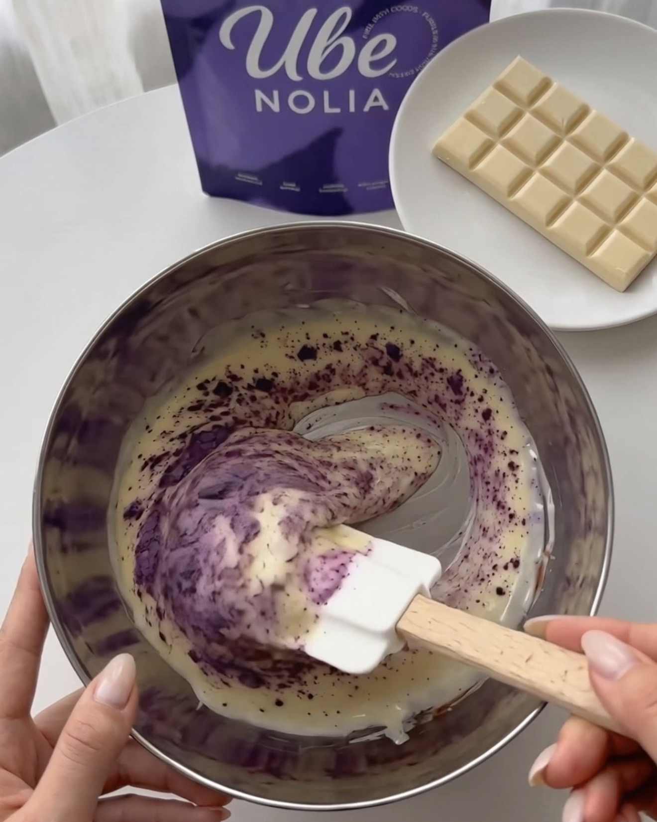 Mélanger la poudre d'ube Ube Nolia au chocolat blanc fondu pour des bouchées de quinoa ube pistache violettes