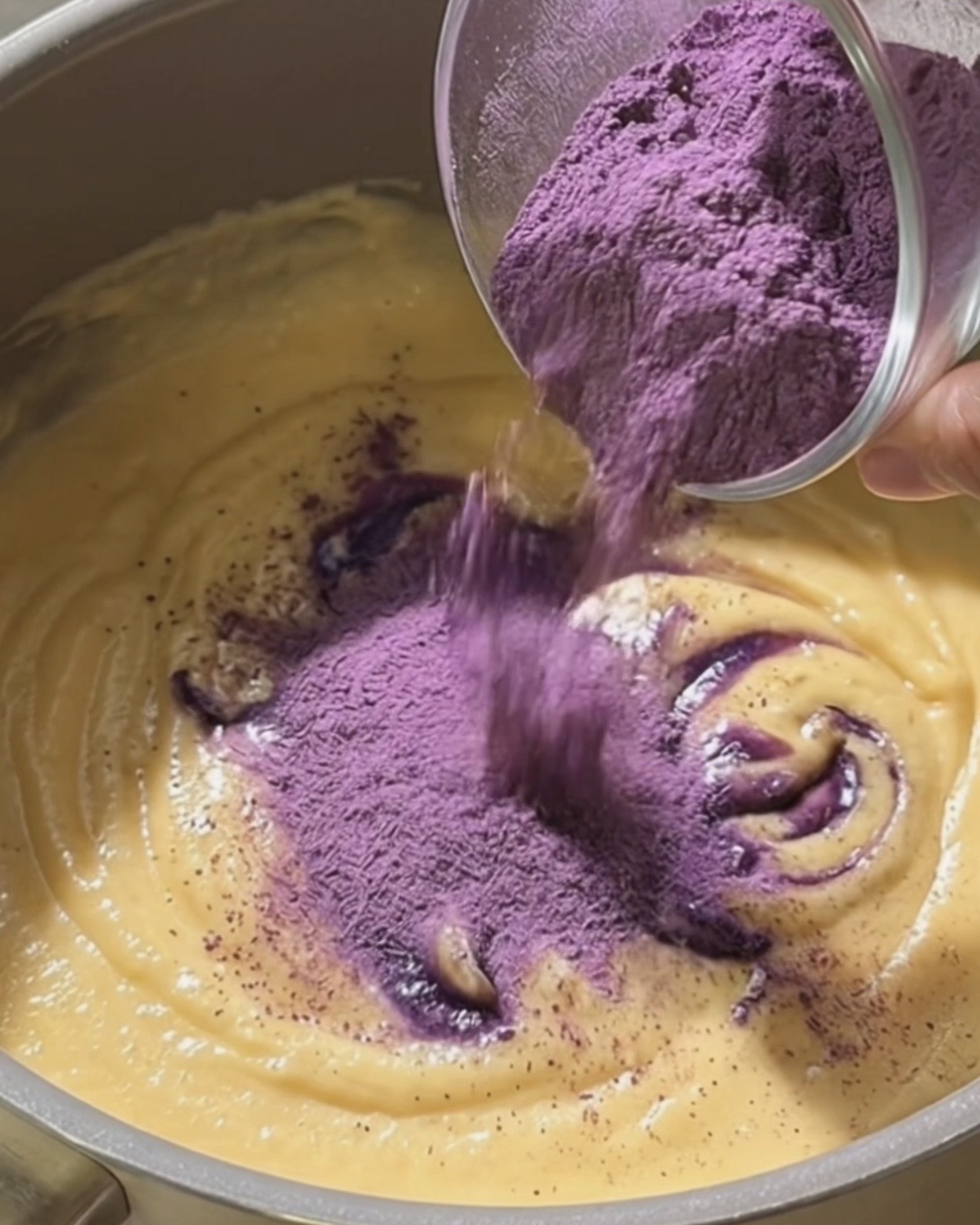 Incorporer l'poudre d'ube Ube Nolia au lait de coco et lait concentré en fouettant pour faire la garniture ube halaya pour dadar gulung