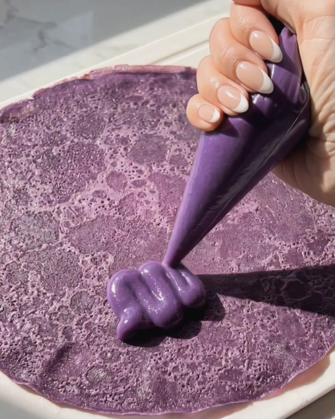 Pocher la garniture ube halaya sur une crêpe ube violette pour l'assemblage du dadar gulung