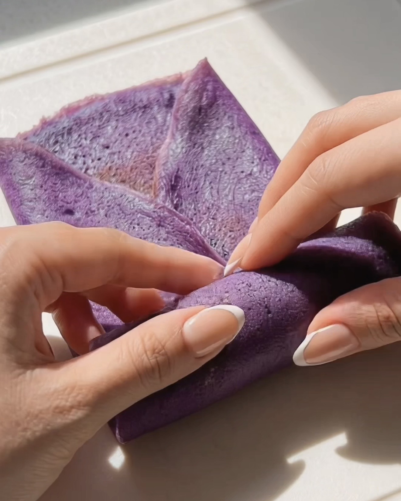 Rouler une crêpe ube dadar gulung en portefeuille autour de la garniture ube halaya violette