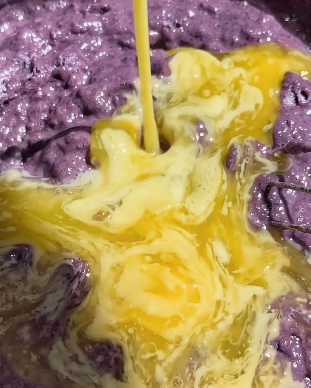 Ajout des œufs dans la pâte violette du banana bread à l'ube | Ube Nolia