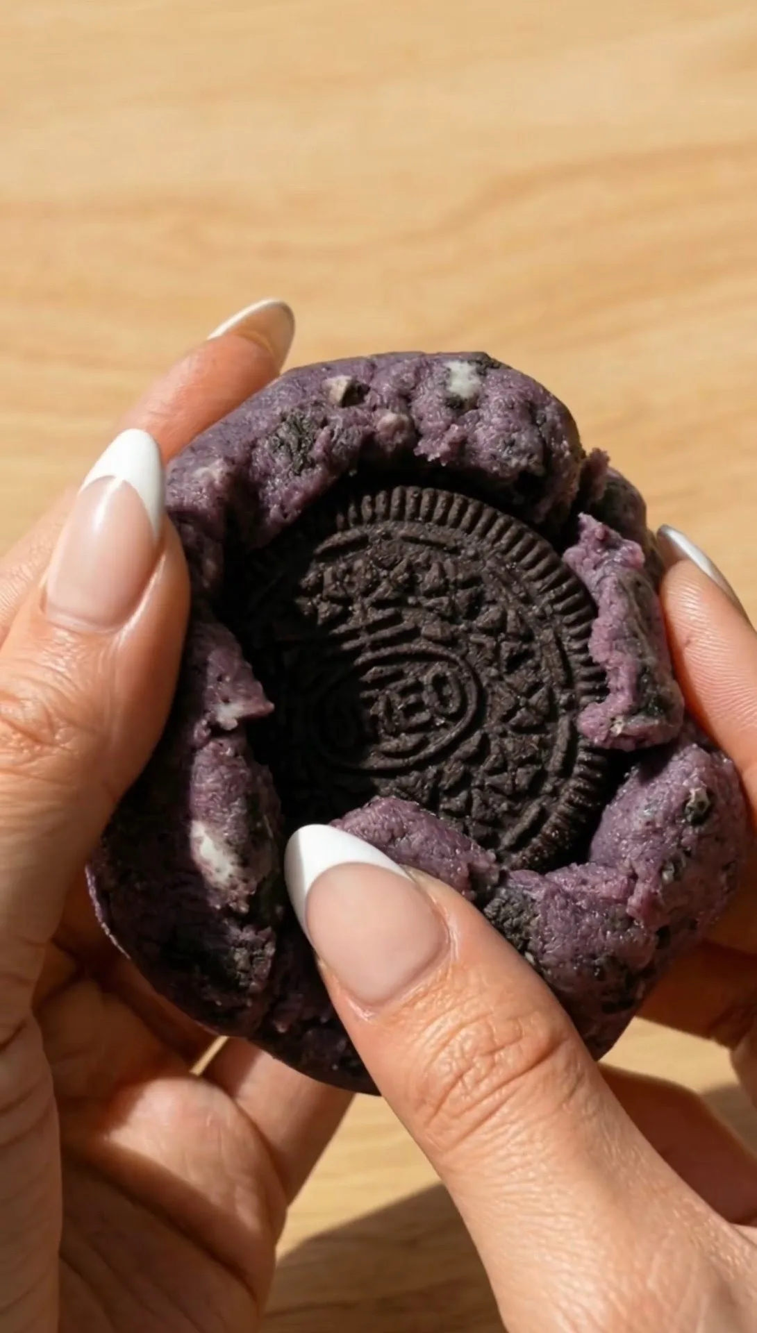 Cookie ube style New York cassé révélant l'Oreo entier farci à l'intérieur de la pâte violette