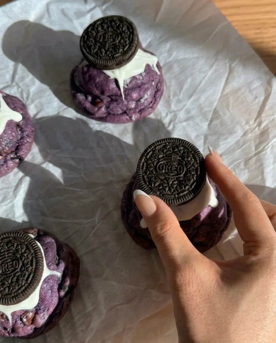 Ube Oreo cookies cuits style New York avec des Oreos entiers pressés sur le dessus et du chocolat blanc dégoulinant
