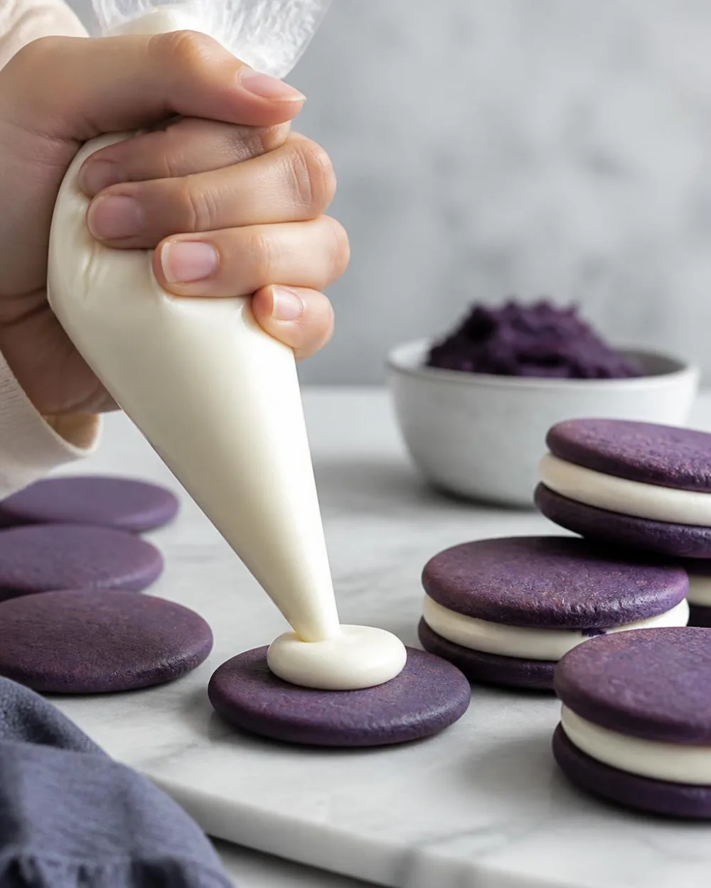 Garniture de biscuits Oreo Ube – pochage de ganache au chocolat blanc sur des gaufrettes ube violettes | Ube Nolia