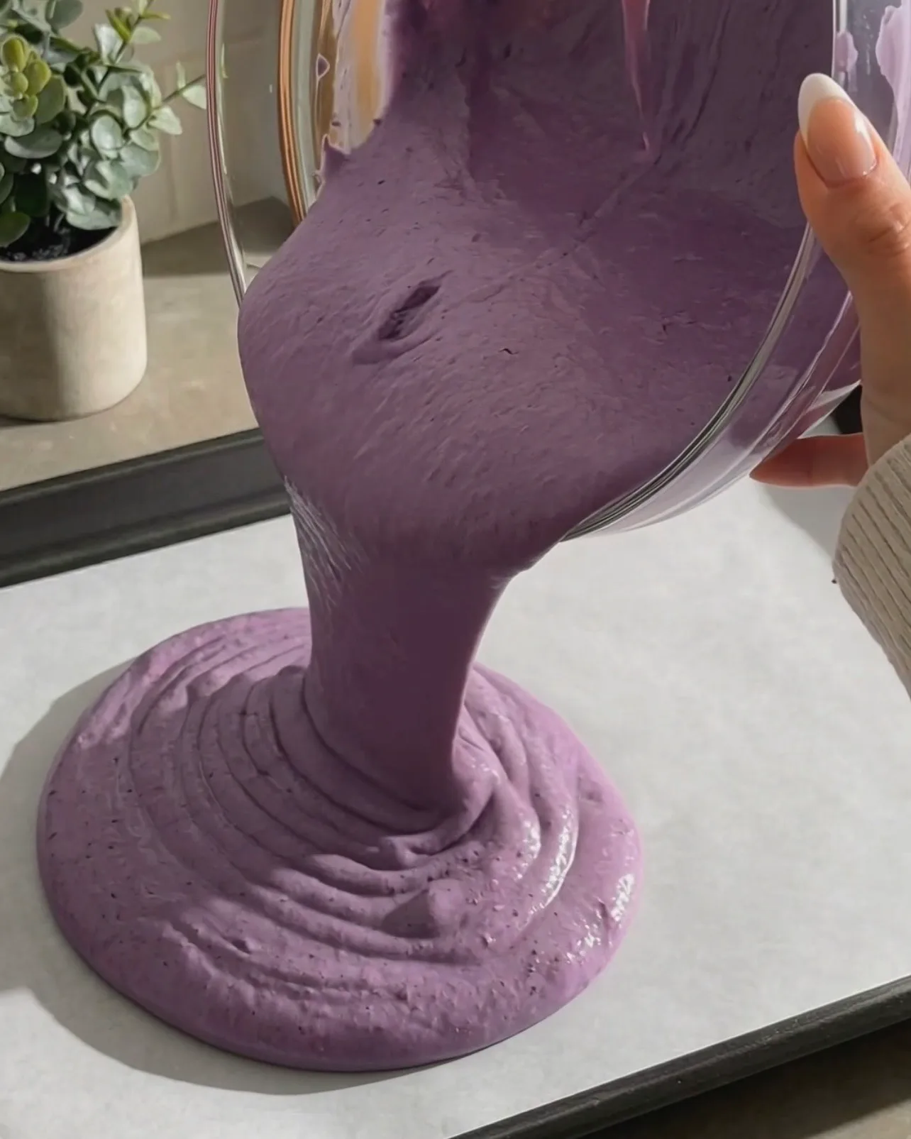 Verser la pâte à gâteau chiffon à l'ube violette vibrante sur une plaque de cuisson tapissée de papier sulfurisé par Ube Nolia
