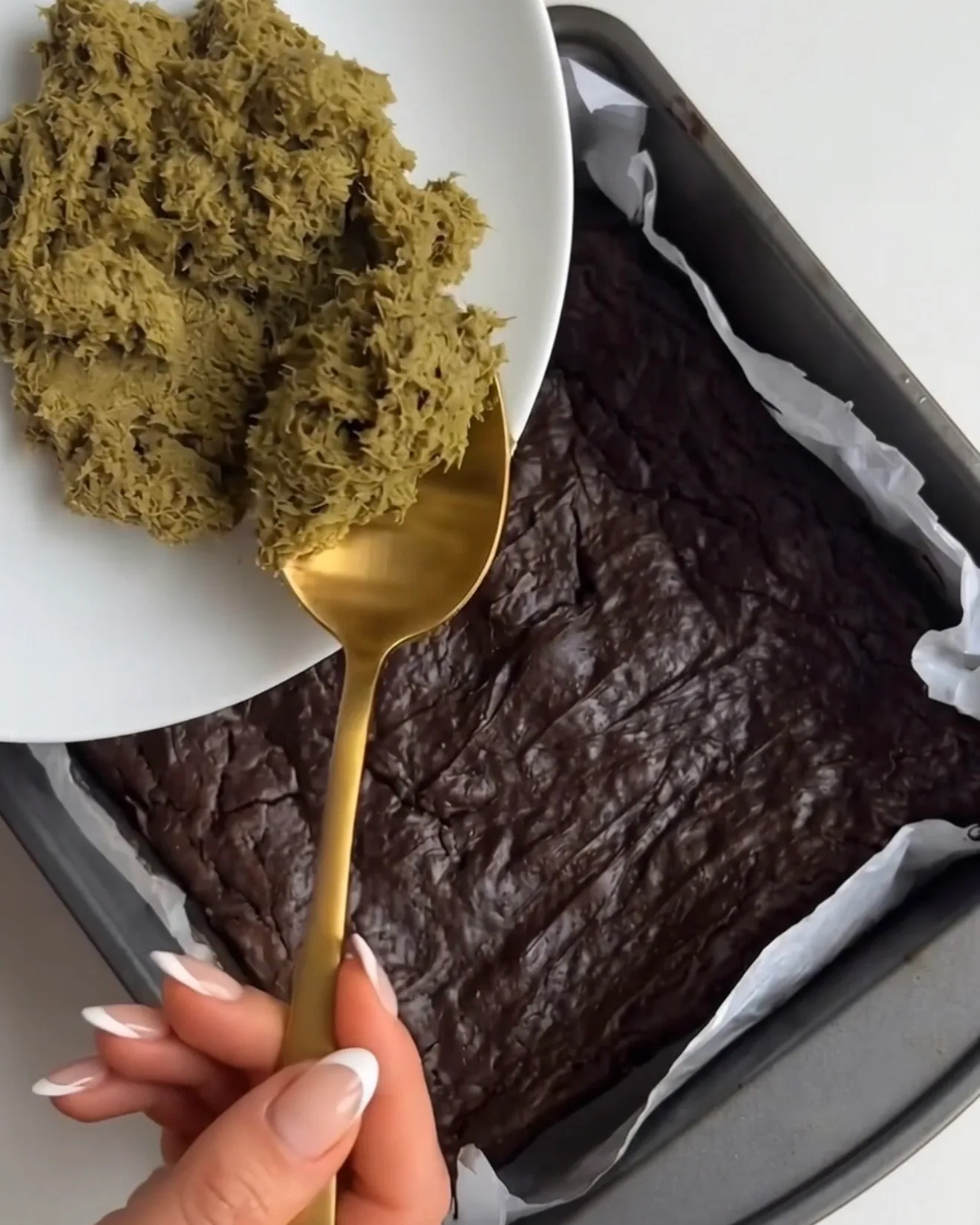 Garniture pistache kataifi déposée à la cuillère sur la base de brownie cuite pour les barres de brownie au chocolat Ube Dubai par Ube Nolia