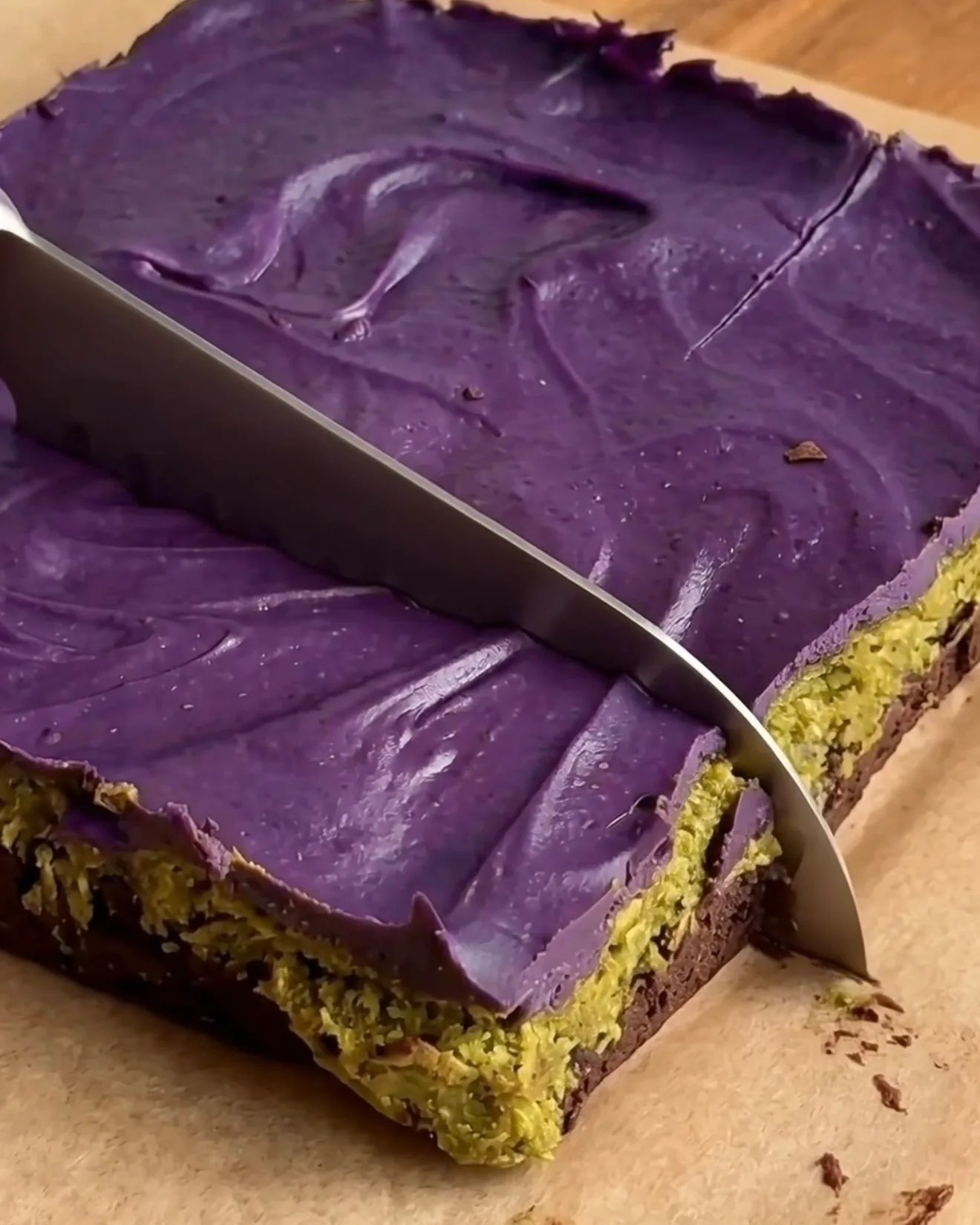 Découpe de barres de brownie au chocolat Ube Dubai réfrigérées montrant les couches de brownie, pistache kataifi et chocolat blanc ube par Ube Nolia